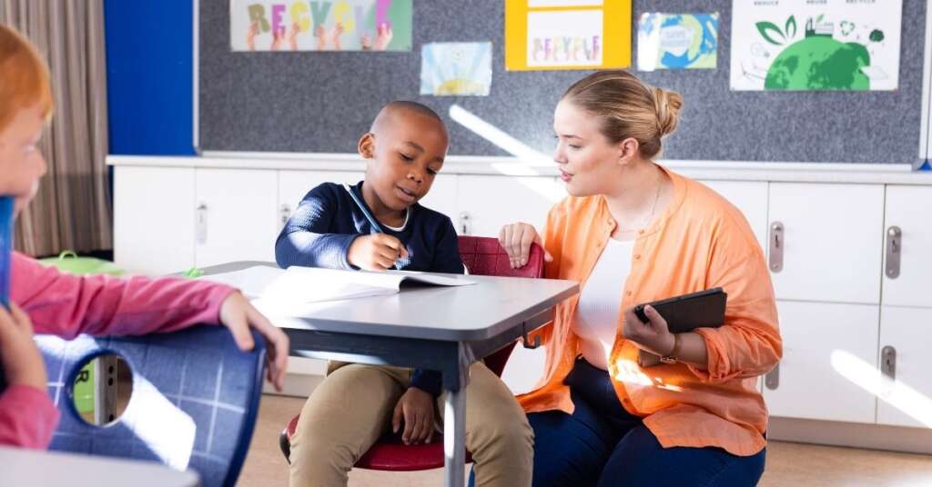 Lehrerin unterstützt einen Schüler im Unterricht – individuelle Förderung für einen gelungenen Schulstart