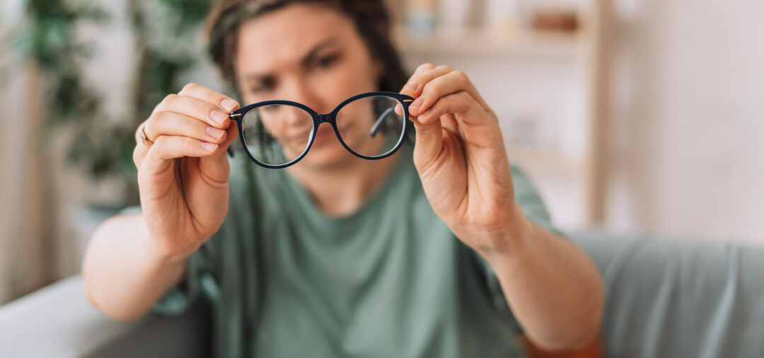 Ein Mädchen überprüft zufrieden ihre Brille und setzt auf die Bedeutung von Omega-3 für gesunde Augen.